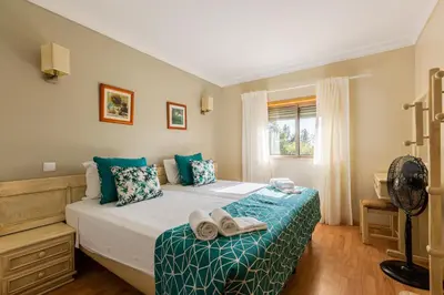a bedroom with a bed with shoes on it at Casa Colina in Albufeira