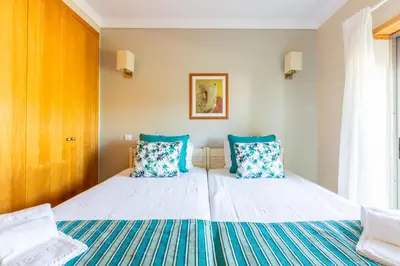 a bedroom with two beds with blue pillows at Casa Colina in Albufeira