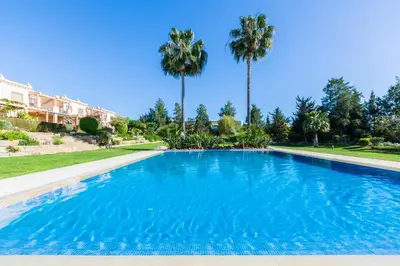 a large swimming pool with palm trees in the background at Casa Colina in Albufeira