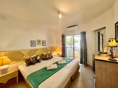 a bedroom with a large bed and a window at Albufeira Balaia Golf Vilage 2 With Pool by Homing in Albufeira
