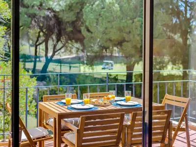 a wooden table with glasses of orange juice on a balcony at AL - Apartamento Vila Sol AG in Vilamoura