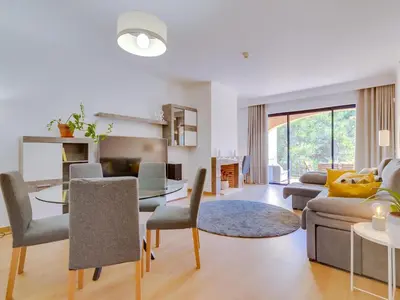 a living room with a couch and a table and chairs at AL - Apartamento Vila Sol AG in Vilamoura