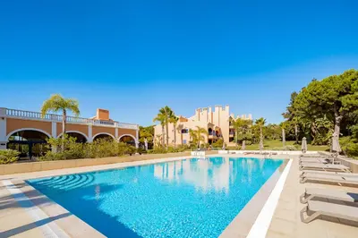 a swimming pool with lounge chairs and a resort at AL - Apartamento Vila Sol AG in Vilamoura