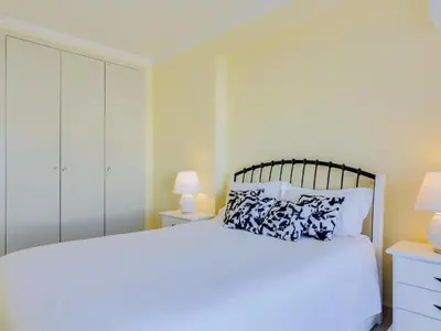 a bedroom with a large white bed and two lamps at AL - Apartamento Falésia Terrace in Vilamoura
