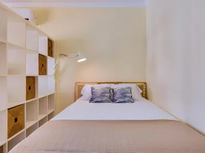 a small bedroom with a bed with white shelves at AL - Apartamento Falésia Terrace in Vilamoura