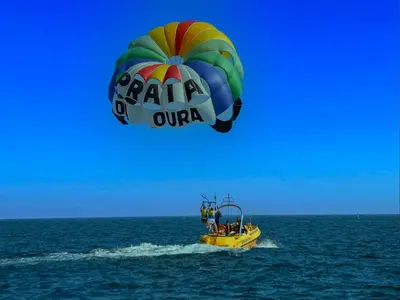 a group of people on a boat in the ocean with a parachute at Luxury Penthouse wStunning Sea Views, walk to Galé Beach Albufeira in Albufeira