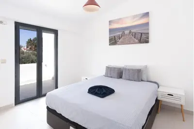 a white bedroom with a bed and a large window at Vilamoura Marina Villa in Vilamoura