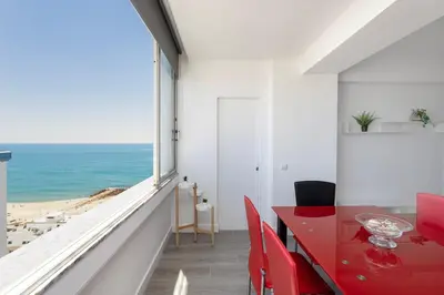 a red dining room with a view of the ocean at Quarteira SeaViews in Quarteira