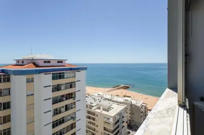 a view of the beach from the balcony of a building at Quarteira SeaViews in Quarteira