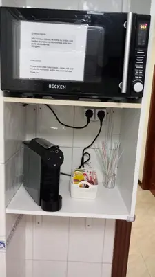 a microwave sitting on top of a shelf at Quarteira Apartamento T2 - Oceanides in Quarteira