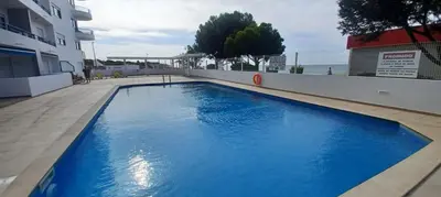 a large blue swimming pool on the side of a building at Quarteira Apartamento T2 - Oceanides in Quarteira