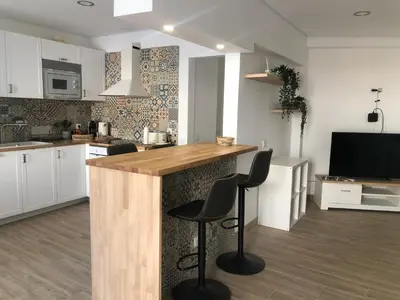 a kitchen with a counter and two stools at Vila Luisa Anabela Piscine et Jacuzzi in Albufeira