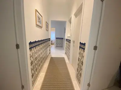 a hallway with a staircase with blue and white tiles at Guest House in Faro