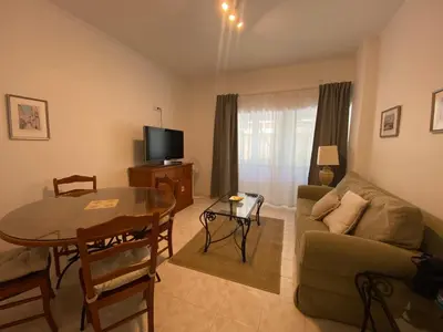 a living room with a couch and a table and a television at Guest House in Faro