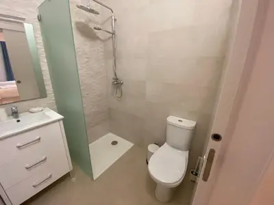 a bathroom with a shower and a toilet and a sink at Guest House in Faro