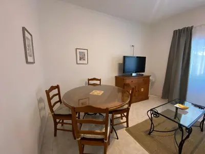 a living room with a table and a television at Guest House in Faro