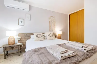 a bedroom with a large white bed with towels on it at Casinha da Jade in Albufeira