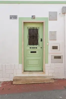 a green door on the side of a building at Casinha da Jade in Albufeira