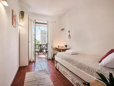 a bedroom with a bed and a door to a balcony at Spacious 3BR Apartment in Vilamoura Old Village with Rooftop BBQ, Pools & Panoramic Views in Quarteira
