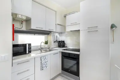 a kitchen with white cabinets and a sink and a microwave at Sea & Oldtown View in Albufeira