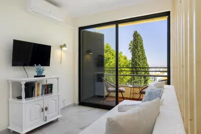 a living room with a white couch and a television at Sea & Oldtown View in Albufeira