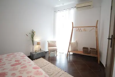 a bedroom with a bed and a chair and a window at Birdy House in Faro