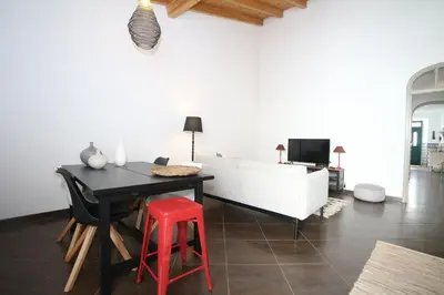a living room with a table and a red stool at Birdy House in Faro